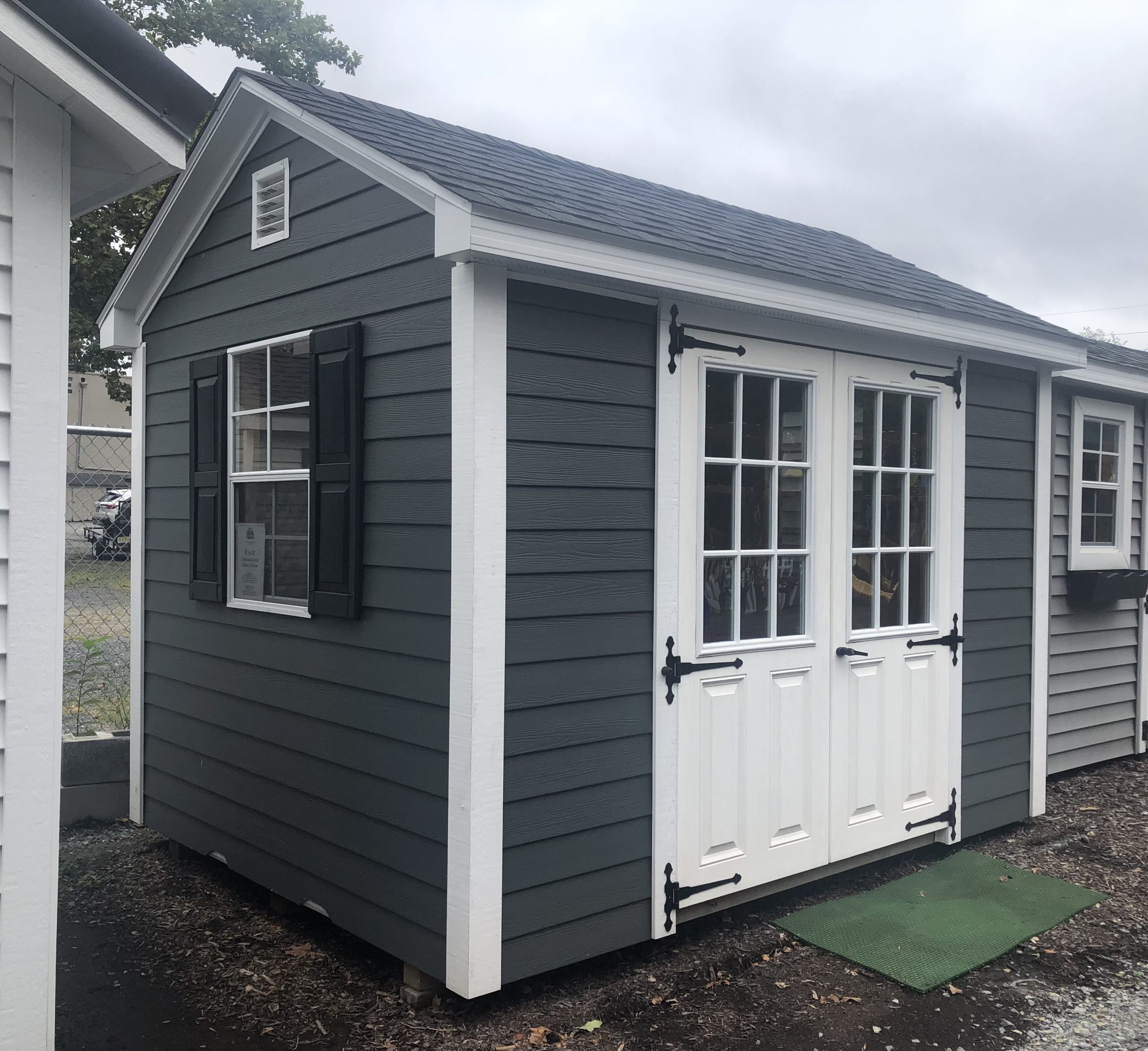 Winchester-Small dark grey shed w/ shingle roof