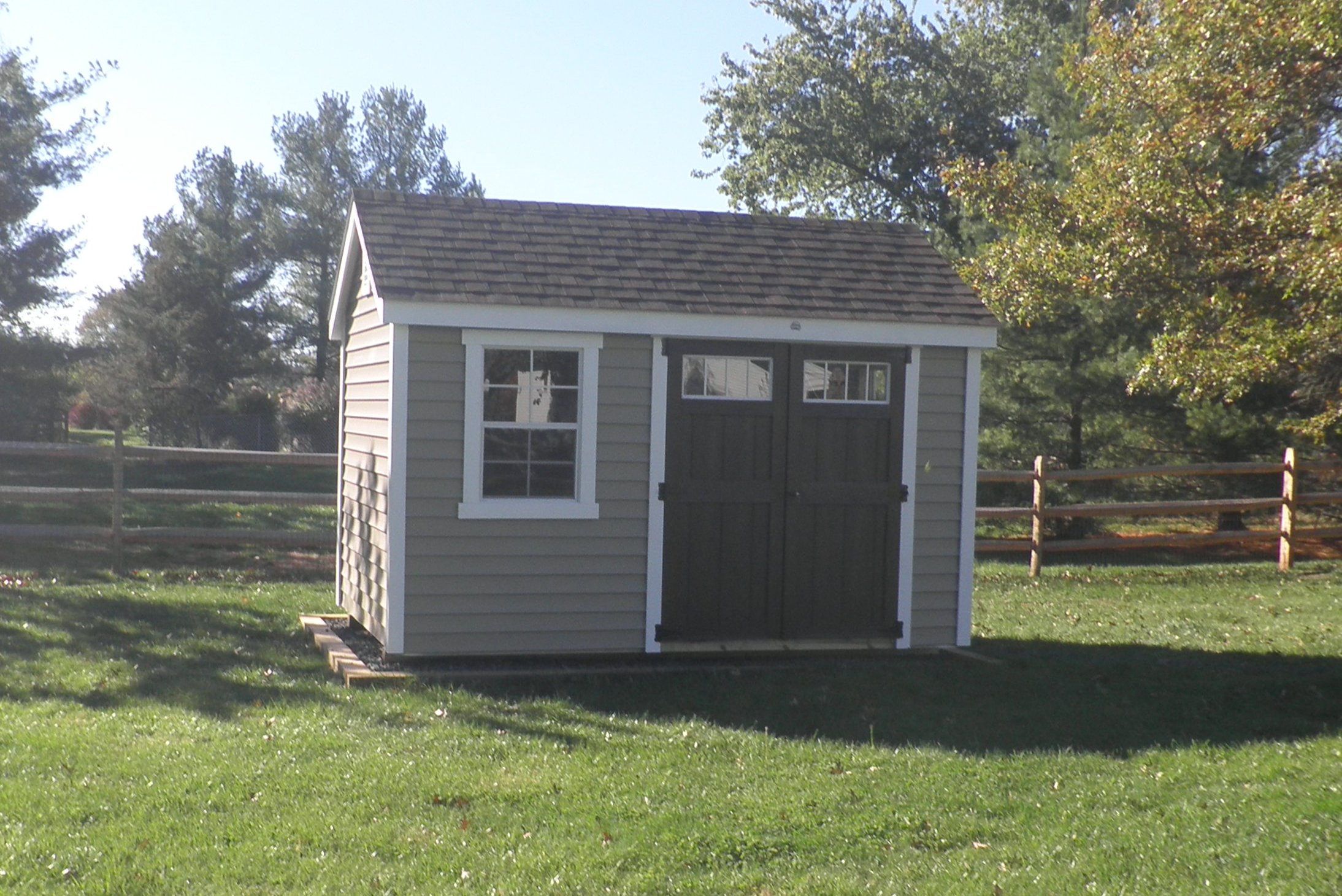 Winchester-Small light brown shed w/ shingle roof